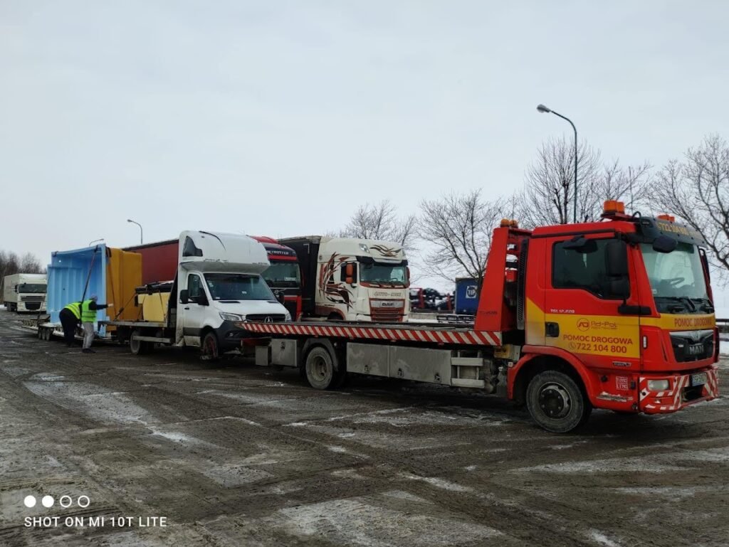 Laweta Kąty Wrocławskie holuje uszkodzony samochód osobowy na drodze w okolicy miasta