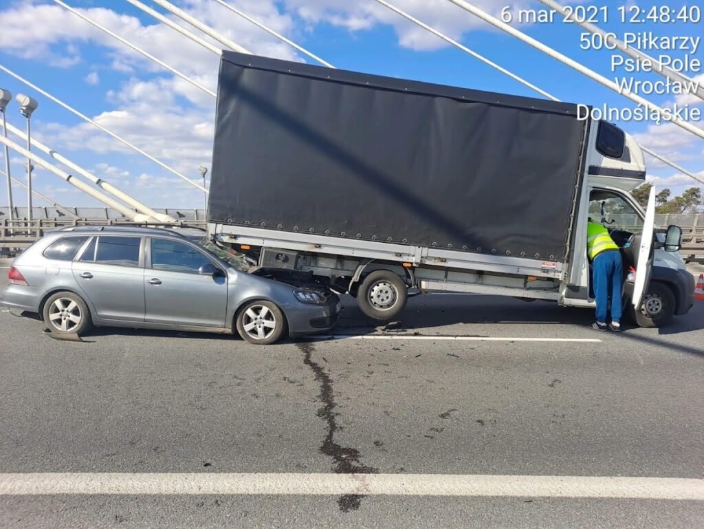 Pomoc drogowa Kąty Wrocławskie podczas holowania uszkodzonego samochodu na lawecie przy drodze lokalnej.